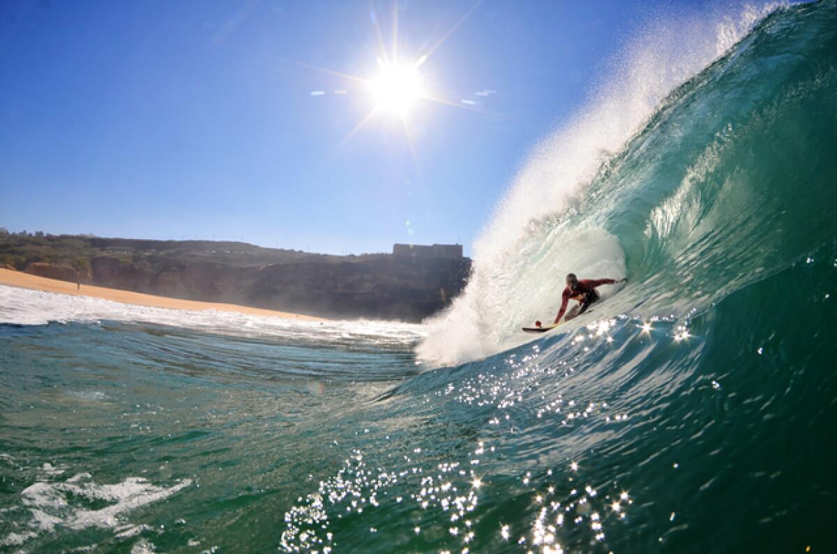 A surfer rides a massive wave