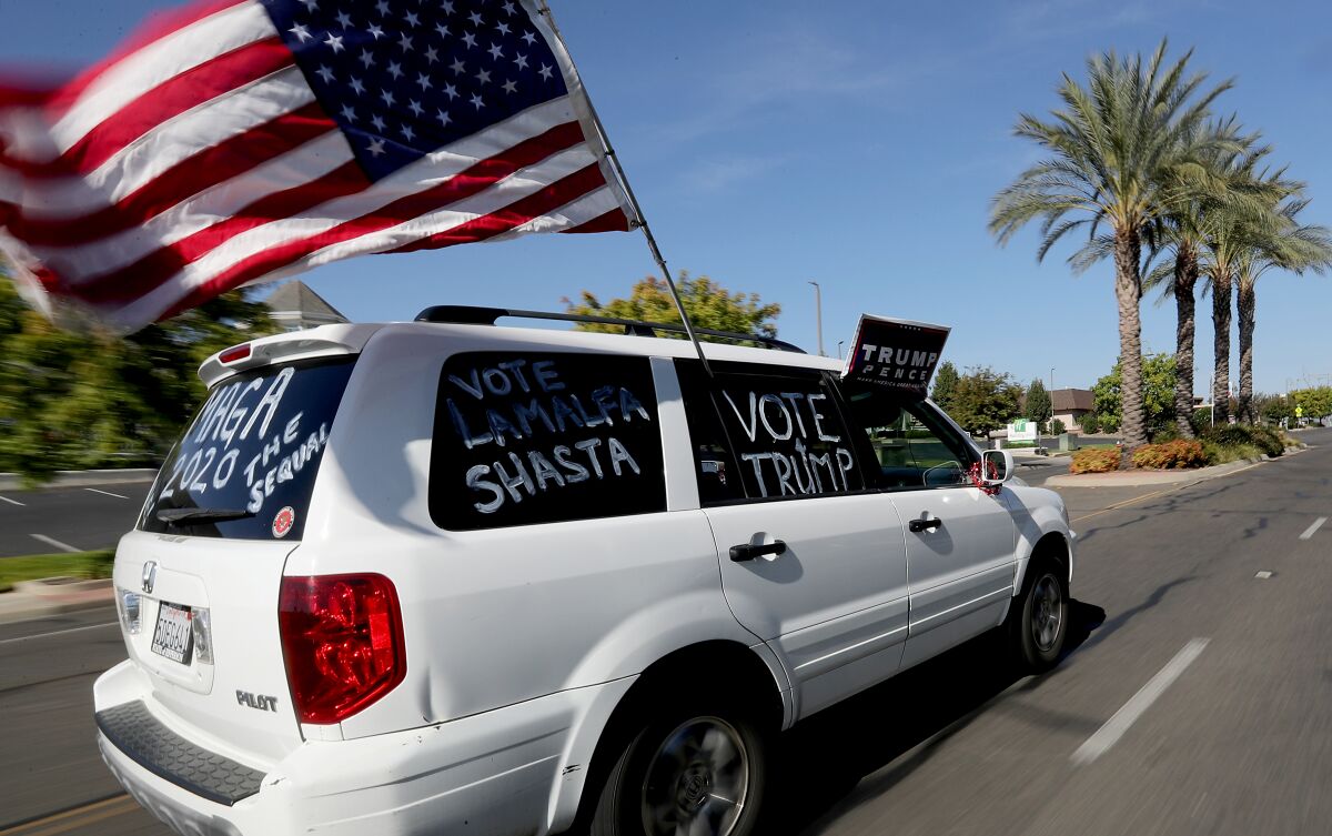 A supporter of President Trump drives through Redding on Oct. 24.