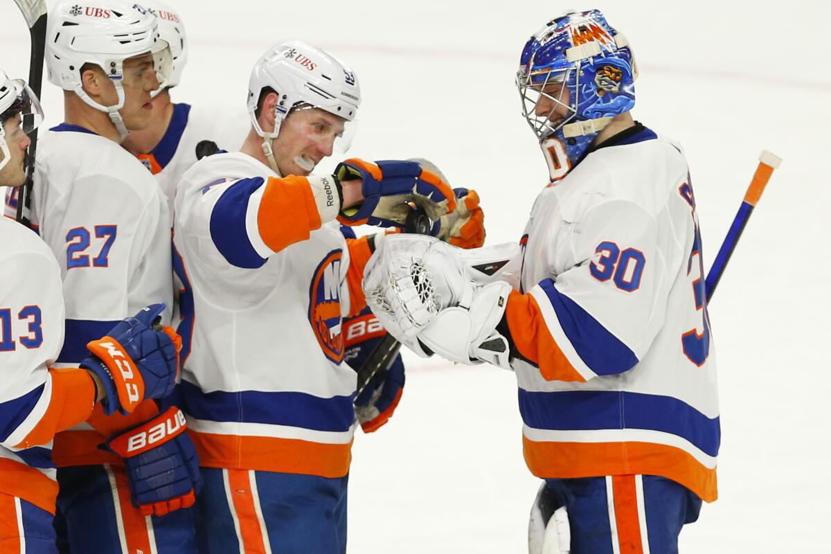 FILE - In this Feb. 16, 2021, file photo, New York Islanders forward Casey Cizikas (53) gives goalie Ilya Sorokin (30) the game puck to celebrate a 3-0 victory following the third period of an NHL hockey game against the Buffalo Sabres in Buffalo, N.Y. The Islanders finalized most of their offseason work in one day by signing four players to multiyear contracts. Goaltender Ilya Sorokin got a three-year deal for $12 million, homegrown forward Anthony Beauvillier three years and $12.45 million, deadline pickup Kyle Palmieri $20 million over four years and fourth-line mainstay Casey Cizikas six years for $15 million. (AP Photo/Jeffrey T. Barnes, File)