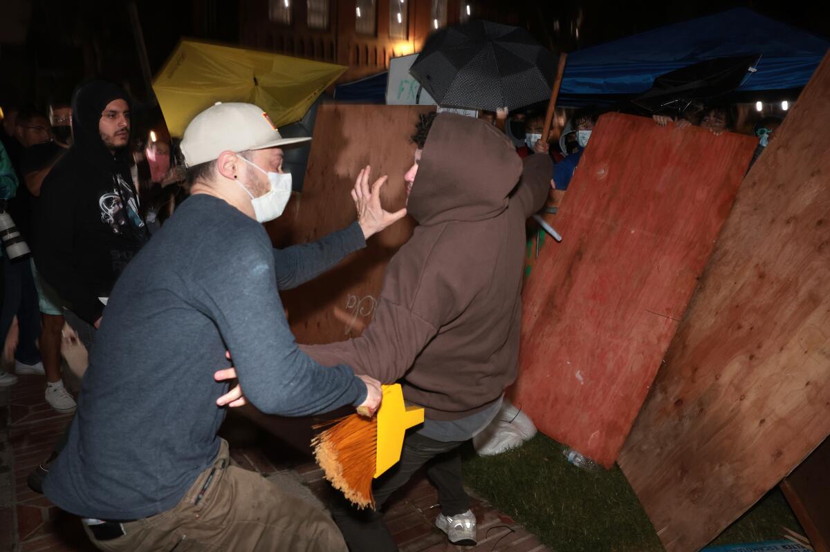 Two men clash outside an encampment. 