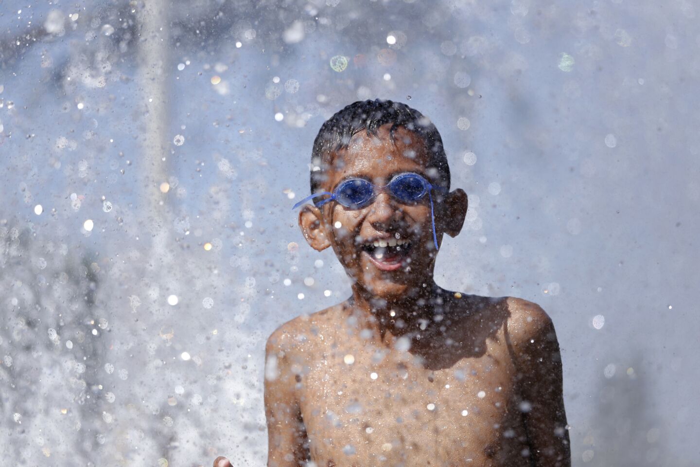 Adrian Rosales cools off at the spray pool at Lemon Park in Fullerton.