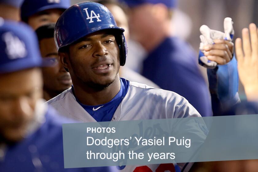 Dodgers center fielder Yasiel Puig is congratulated by teammates after scoring against the Angels during a game in Anaheim last season.