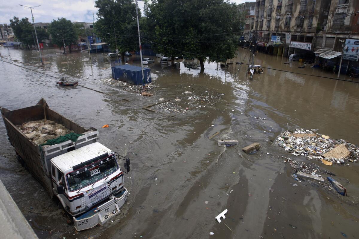 A truck drives through a flooded road after a heavy rainfall in Karachi, Pakistan, Monday, July 11, 2022. The death toll from rain-related incidents over the past month has risen to over 140 as monsoon rains continue to lash Pakistan, triggering flash floods in some parts of the country, officials said. (AP Photo/Fareed Khan)