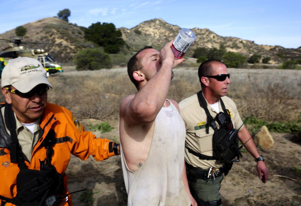 Hiker Brian Napoli is escorted by rescuers Tuesday after being airlifted from Towsley Canyon.