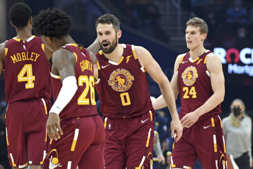 Cleveland Cavaliers' Kevin Love (0) celebrates with Brandon Goodwin (26) in the first half of an NBA basketball game against the Indiana Pacers, Sunday, Jan. 2, 2022, in Cleveland. (AP Photo/Nick Cammett)