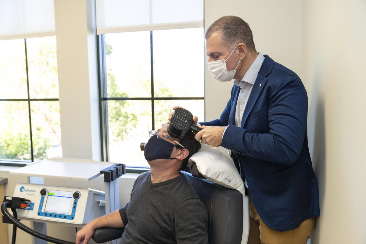 Dr. Zafiris "Jeff" Daskalakis administers a transcranial magnetic stimulation, or TMS, treatment.