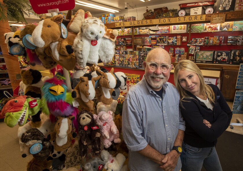 A man and woman stand next to a toy display.