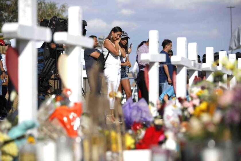 Personas visitan un altar improvisado el lunes 5 de agosto de 2019, en el lugar de una masacre en un centro comercial de El Paso, Texas.