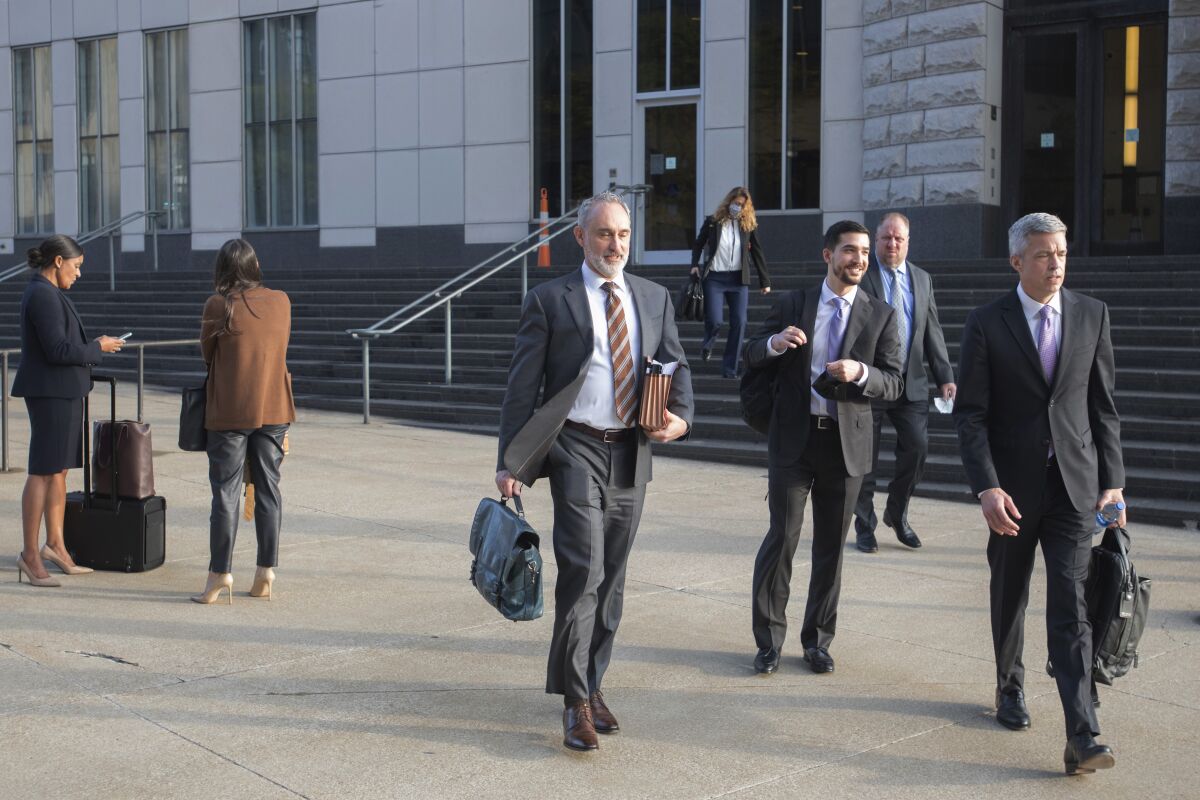 Attorneys and staff associated with a federal trial of pharmacies, CVS, Walgreens, Giant Eagle and Walmart leave the Carl B. Stokes Federal Courthouse in Cleveland, Monday, Oct. 4, 2021. The pharmacies are being sued by Ohio counties Lake and Trumbull for their part in the opioid crisis. (AP Photo/Phil Long)
