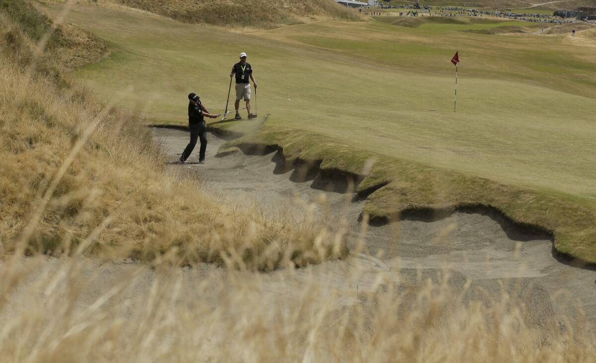 Byeong-Hun An, of South Korea, hits out of the bunker on the first hole during a practice round for the U.S. Open golf tournament at Chambers Bay on Monday