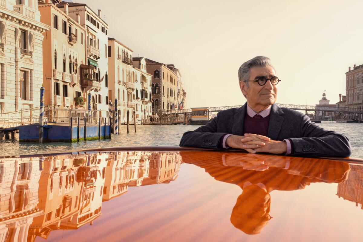 The actor Eugene Levy stands in a boat in Venice's canals.