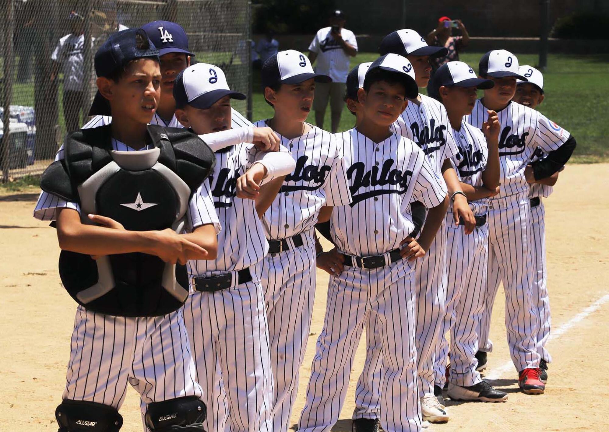 Youth baseball players lined up on baseline. 