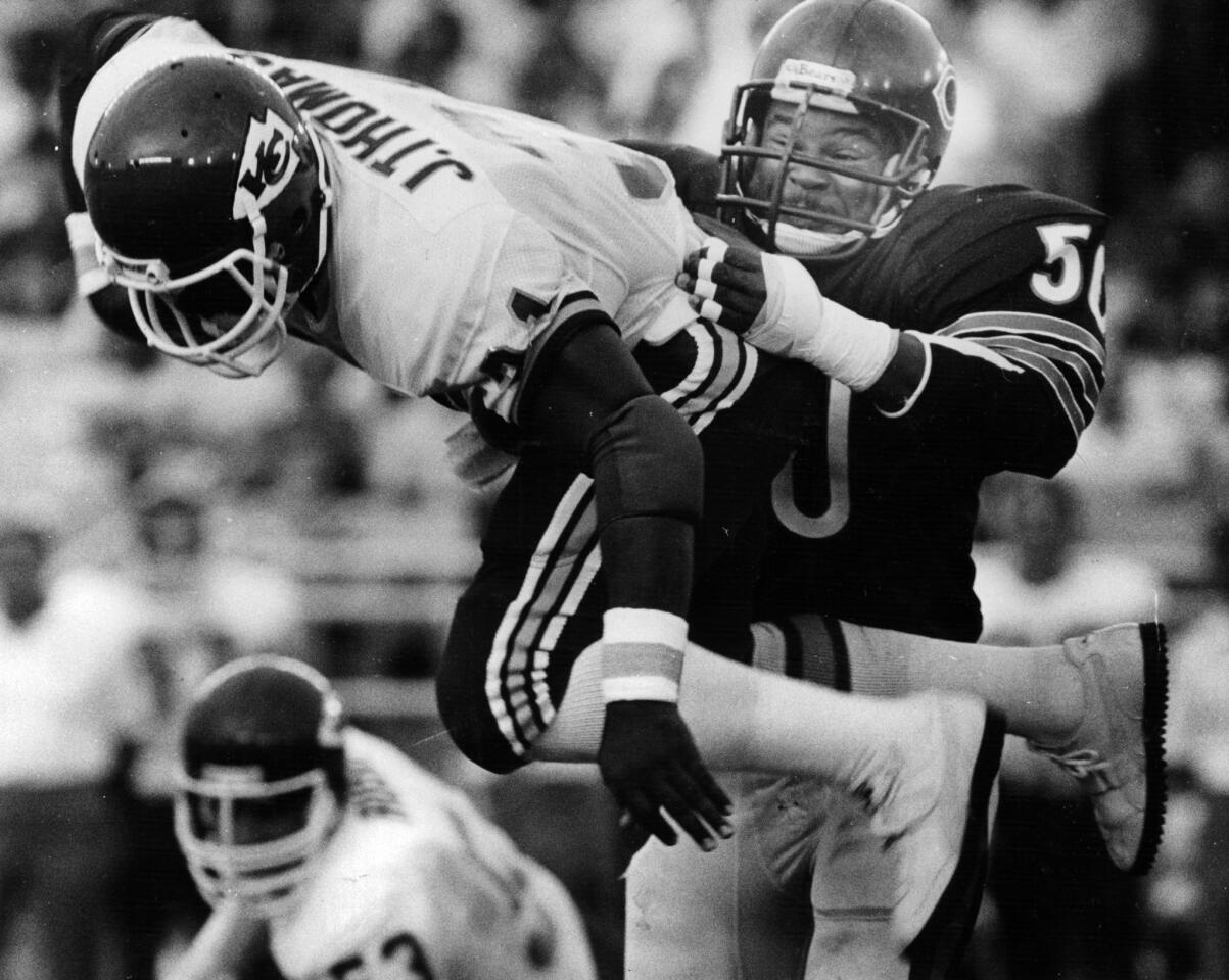 Bear linebacker Mike Singletary makes sure Kansas City's Jewerl Thomas gets in the swing of things on Aug. 28, 1983, at Soldier Field. (Ed Wagner Jr./Chicago Tribune)