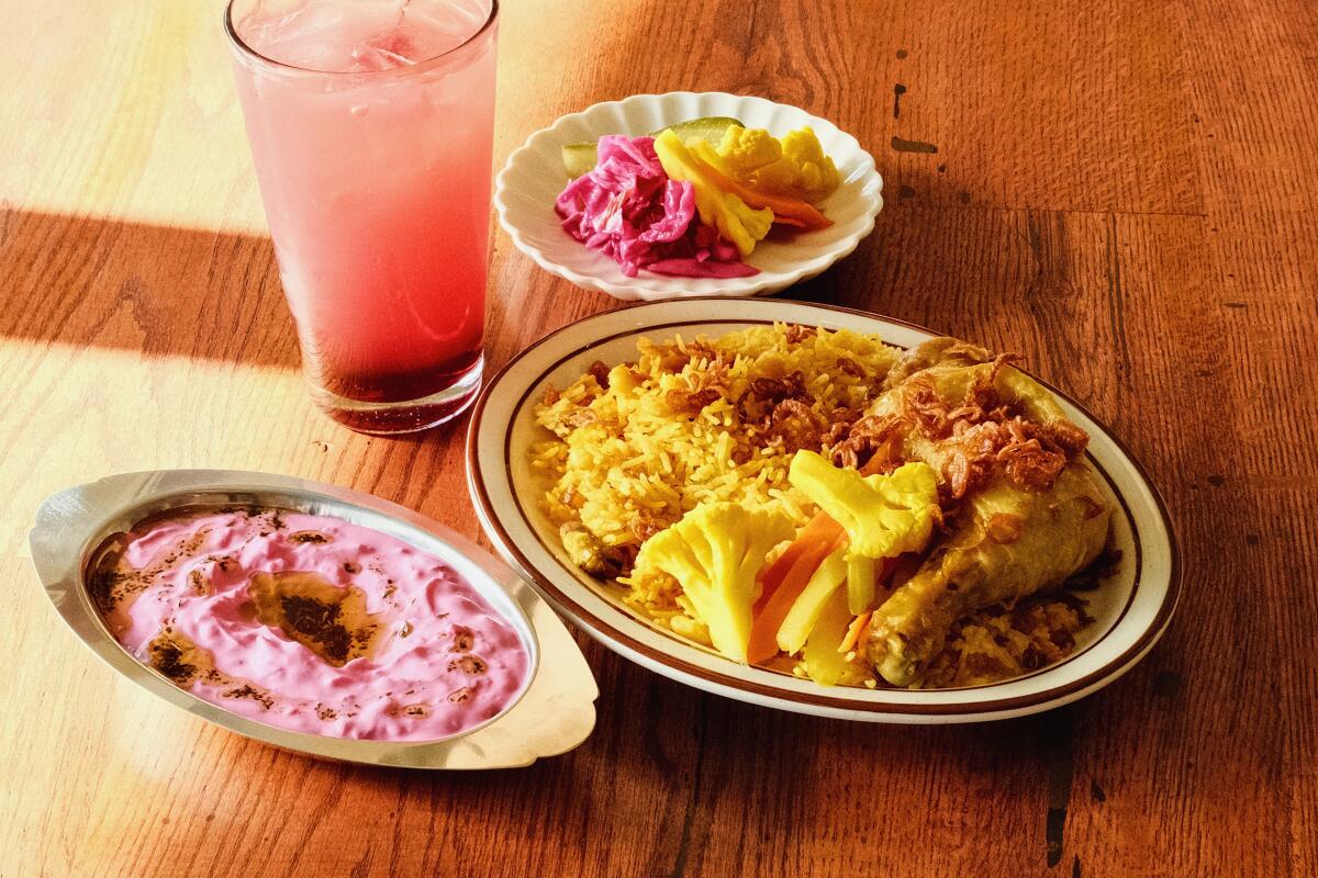 A horizontal photo of chicken with turmeric rice, pickles and a sour cherry limeade at Azizam restaurant in Silver Lake.