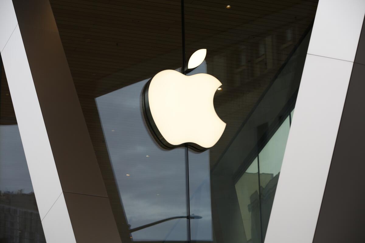 A white Apple logo adorns the glass facade of the downtown Brooklyn Apple store in New York