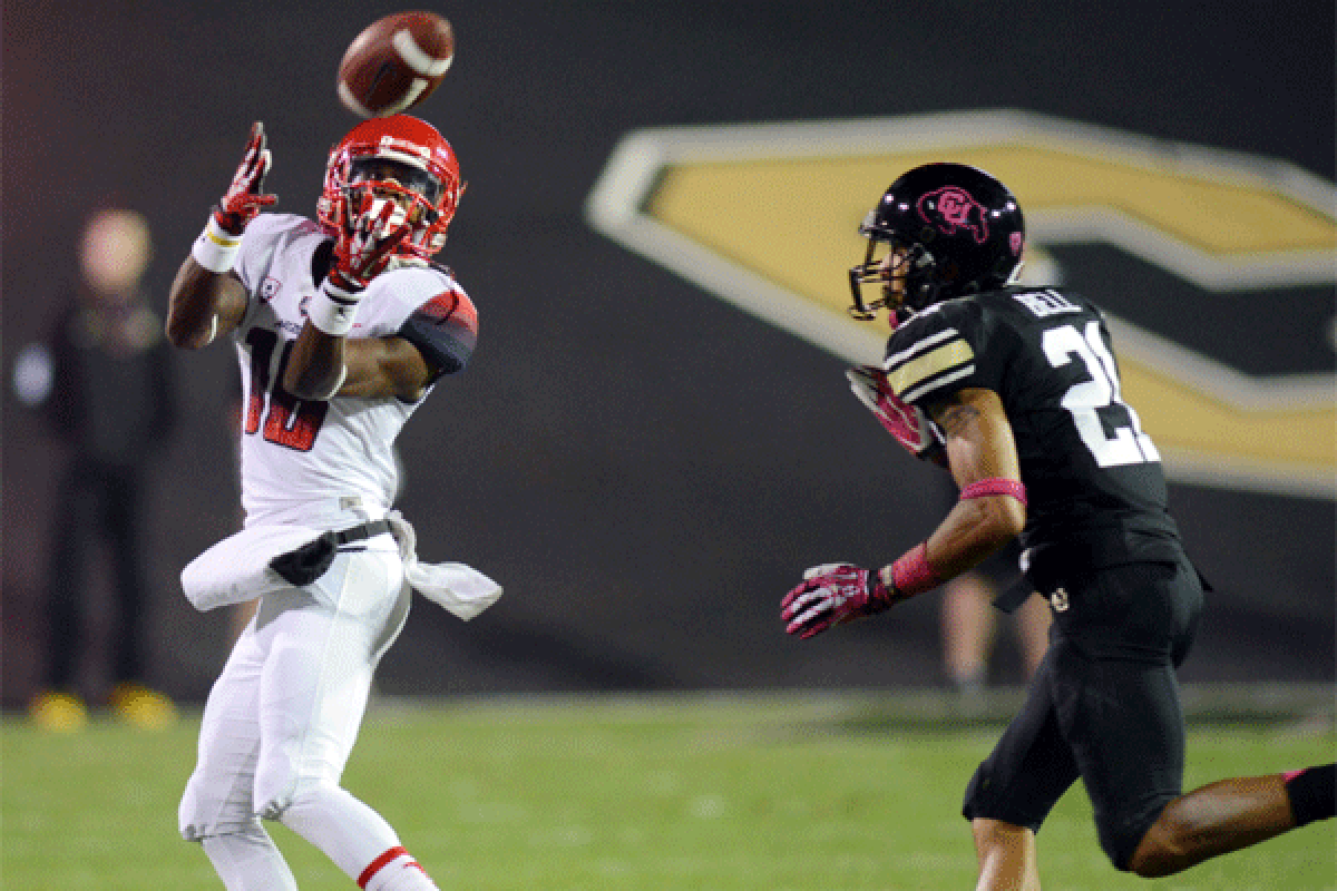 Arizona's Terrence Miller makes a long catch over Colorado's Greg Henderson during the Wildcats' 44-20 win Saturday.