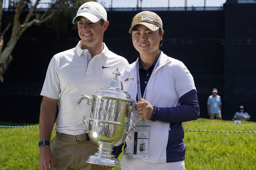 2021 U.S. Women's Open golf champion Yuka Saso, of the Philippines, poses with her champions trophy with Rory McIlroy, of Northern Ireland, during a practice round of the U.S. Open Golf Championship, Tuesday, June 15, 2021, at Torrey Pines Golf Course in San Diego. (AP Photo/Gregory Bull)