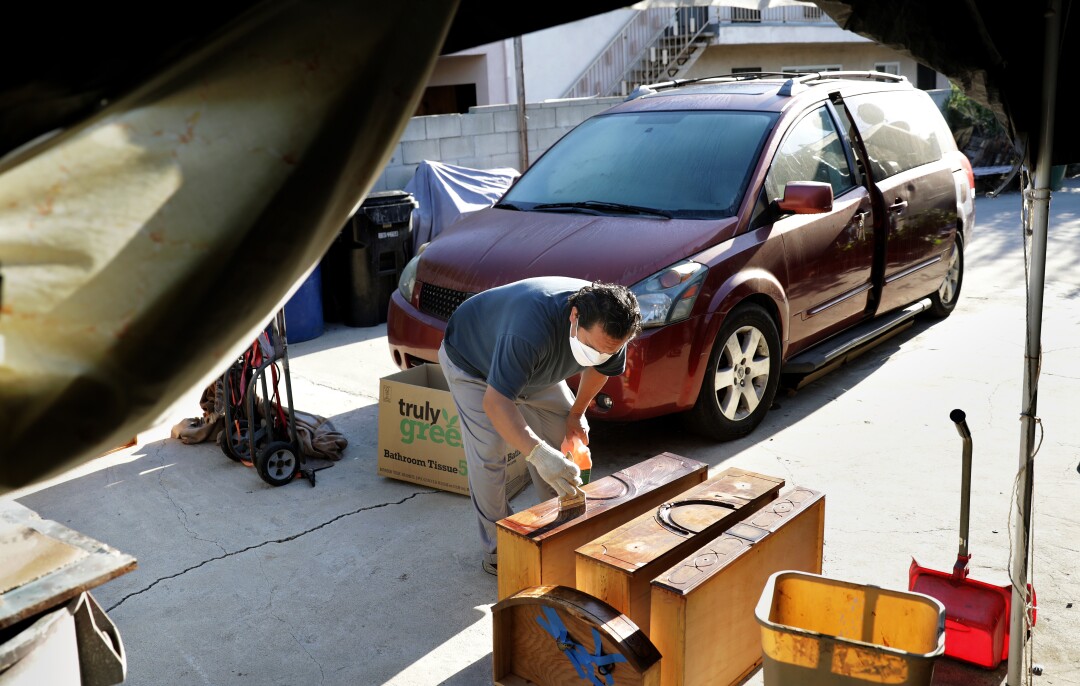 Mario Alarcon works on restoring an antique dresser.