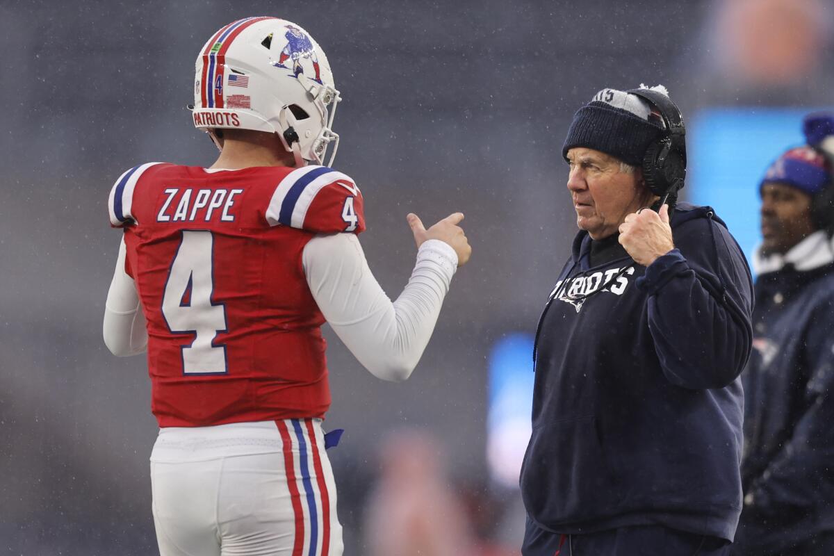 New England Patriots coach Bill Belichick, right, talks with quarterback Bailey Zappe during the second half.