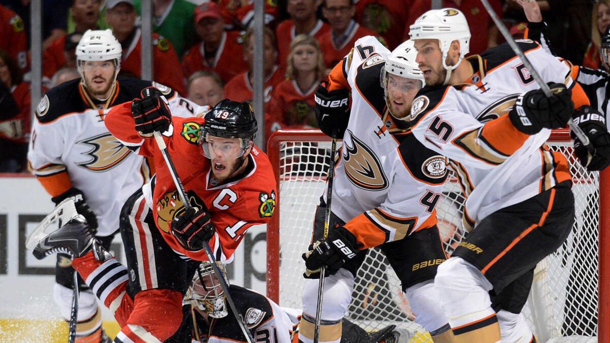 Chicago Blackhawks captain Jonathan Toews, left, fights for position in front of the net as Ducks defenseman Cam Fowler, center, and captain Ryan Getzlaf look on during Game 6 of the Western Conference finals on Wednesday.