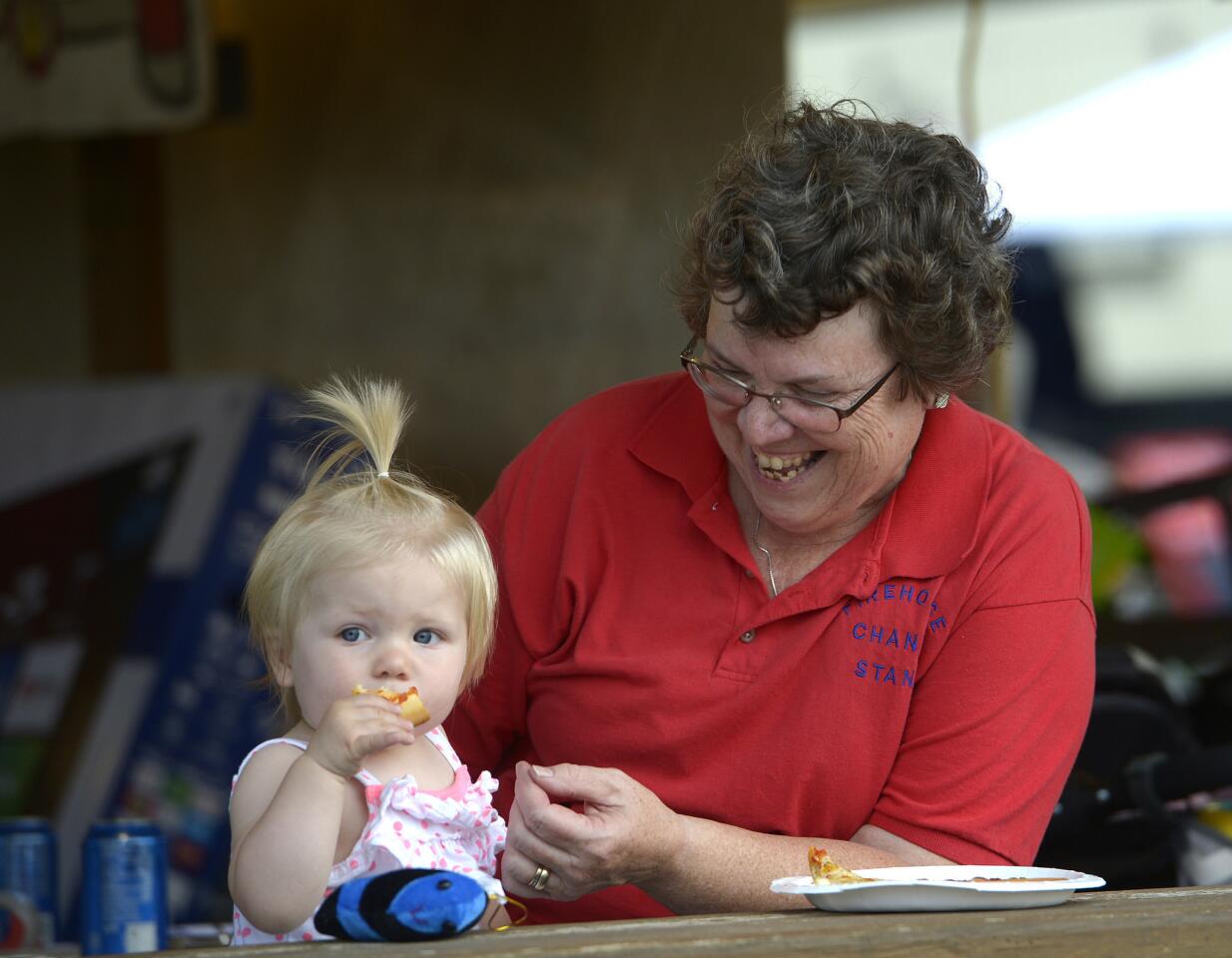 Fire company volunteer Cheryl Keeney shares a slice of pizza with her grandaughter Lucy Keeney, 1, while working a booth at the Union Bridge fire company carnival May 28.