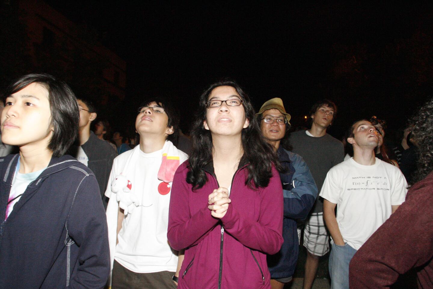Annie Lee, center, and other students watch over 400 pumpkins drop from the ninth floor during Caltech's Annual Halloween Pumpkin drop, which took place at the Caltech's Millikan Library in Pasadena on Wednesday, October 31, 2012.