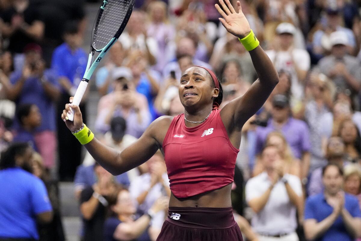 Coco Gauff holds her racket up as she waves to spectator after winning the after U.S. Open women's singles final on Saturday.