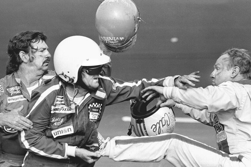 PDN B&W C1 SP 0213 FIGHT -- 47P3X33P4 -- Bobby Allison holds race driver Cale Yarborough's foot after Yarborough kicked him following an argument February 18, 1979 when Yarborough stopped his car during the final lap of the Daytona 500. Allison's brother Donnie was involved in a wreck with Yarborough on the final lap which made brother Bobby stop. (AP Photo/Ric Feld)