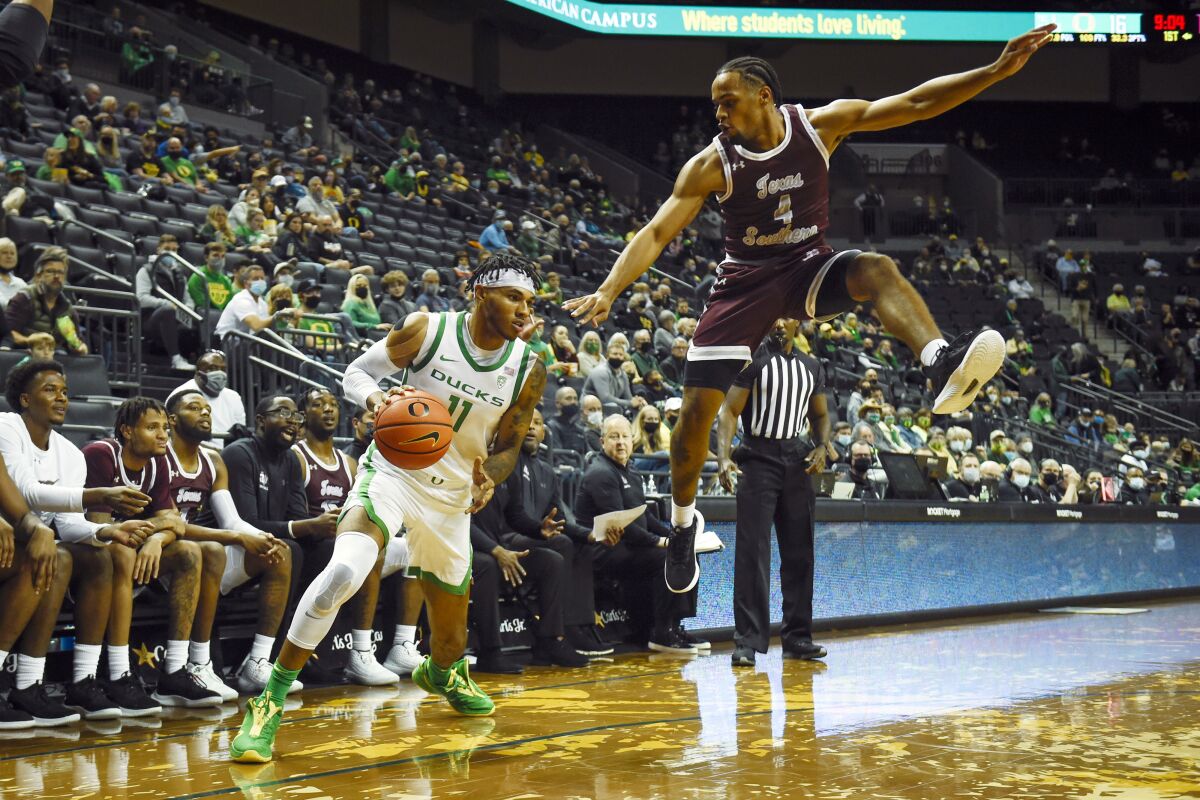 Oregon guard Rivaldo Soares (11) drives after getting Texas Southern guard Bryson Etienne (4) off his feet during the first half of an NCAA college basketball game Tuesday, Nov. 9, 2021, in Eugene, Ore. (AP Photo/Andy Nelson)