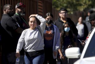 Students and adults walk along Fountain Street following a shooting at a school campus in Oakland, Calif., on Wednesday, Sept. 28, 2022. (Ray Chavez/Bay Area News Group via AP)