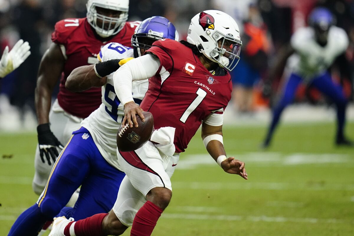 Arizona Cardinals quarterback Kyler Murray is chased by Minnesota Vikings defensive end Danielle Hunter during Sunday's game.