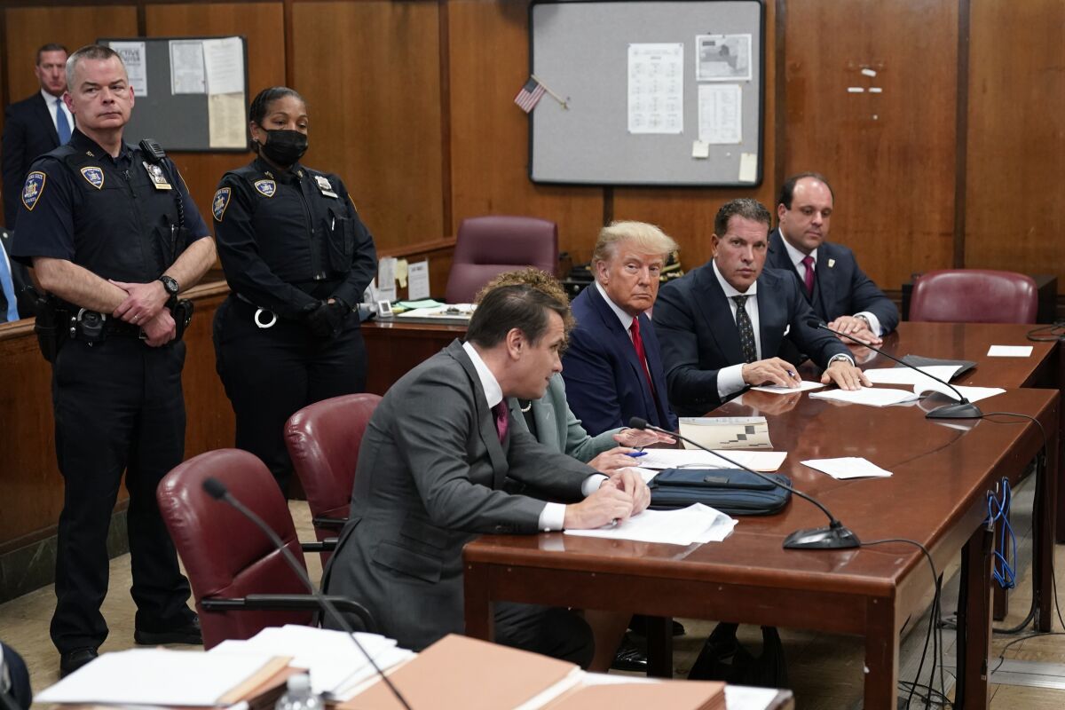 Former President Donald Trump sits at the defense table with his defense team in a Manhattan court, Tuesday, April 4, 2023, in New York. Trump surrendered to authorities ahead of his arraignment on criminal charges stemming from a hush money payment to a porn actor during his 2016 campaign. (AP Photo/Seth Wenig, Pool)