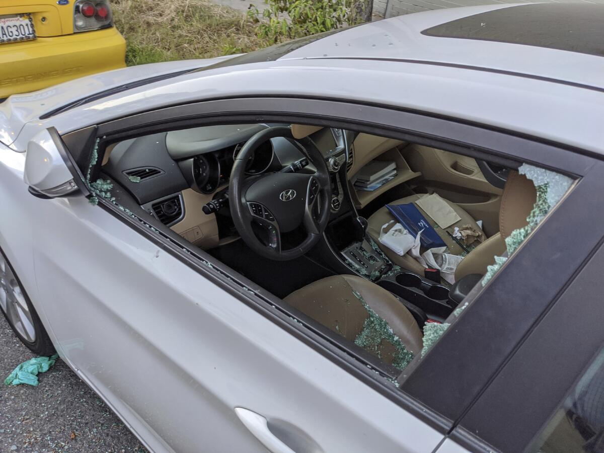 A parked car with a broken driver's side window 