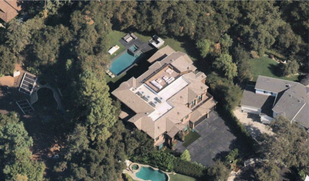 An aerial view of a mansion surrounded by trees.