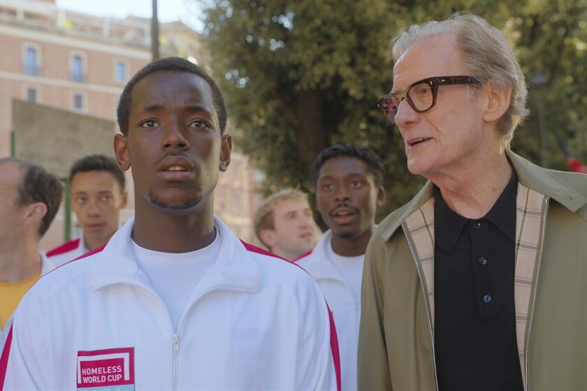 This image released by Netflix shows Micheal Ward, foreground left, and Bill Nighy in a scene from "The Beautiful Game." (Alfredo Falvo/Netflix via AP)