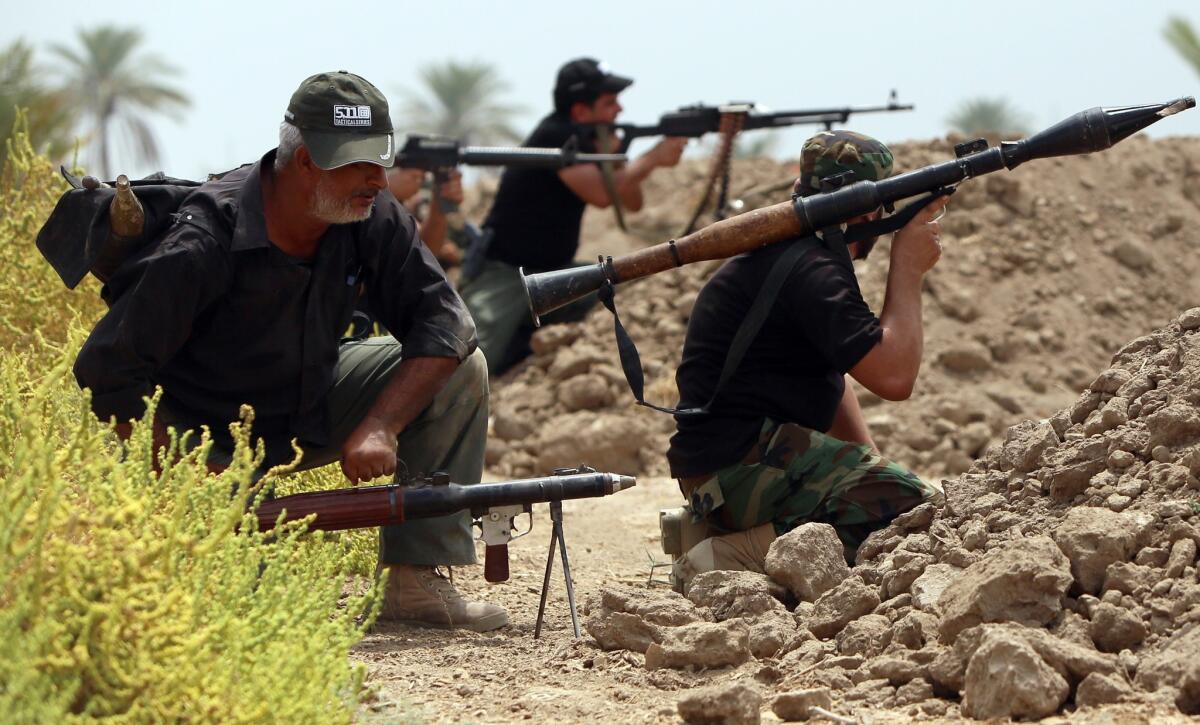 Shiite Muslim fighters with the Peace Brigade, a militia formed by Iraqi cleric Muqtada Sadr, hold a position on the Jarf Sakhr front line souuthwest of Bahgdad on Monday.