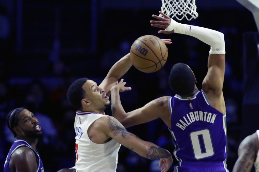 Los Angeles Clippers guard Amir Coffey, center, blocks a shot by Sacramento Kings guard Tyrese Haliburton (0) during the second half of a preseason NBA basketball game Wednesday, Oct. 6, 2021, in Los Angeles. (AP Photo/Alex Gallardo)