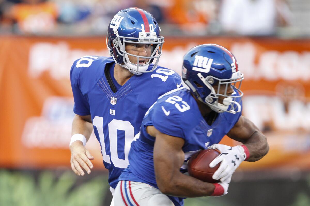 New York Giants quarterback Eli Manning hands the ball off to running back Rashad Jennings on Aug. 14.