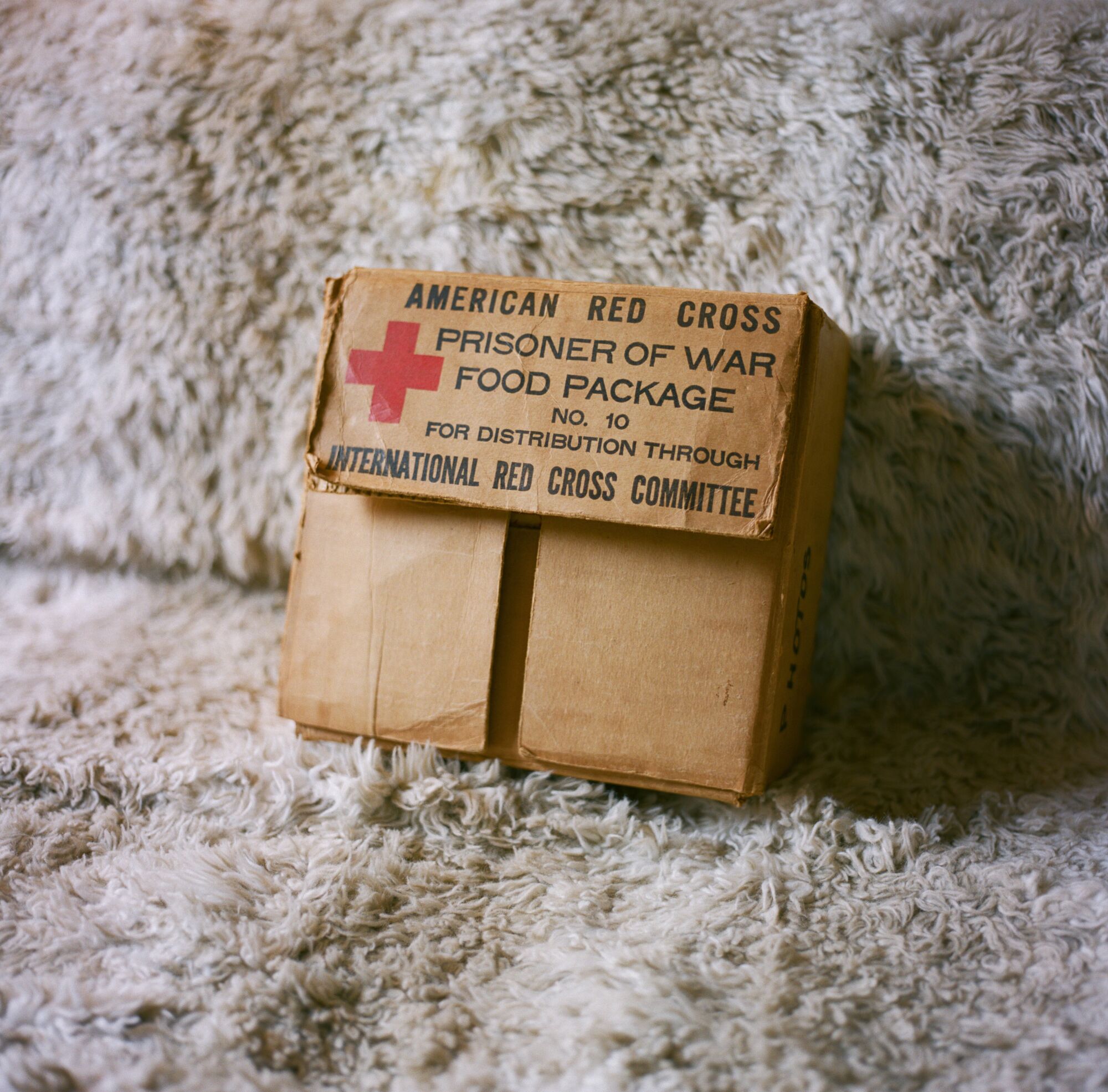Andrzej’s box inscribed, “American Red Cross Prisoner of War Food Package,” sits on the couch in his living room.