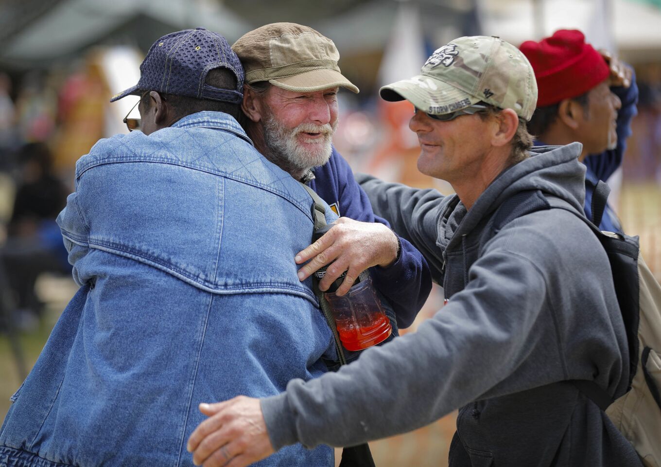 Navy veteran Sean Reilly, center, who has been homeless off and on over the past 15-years gets a hug from from friends during Stand Down 2018 at San Diego High School. The annual three-day event hosted by Veterans Village of San Diego began Friday and will help 800 veterans and their family members with a wide variety of services.