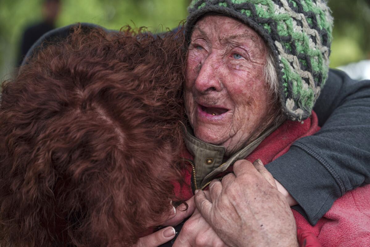 A woman hugs her elderly mother as they evacuate.