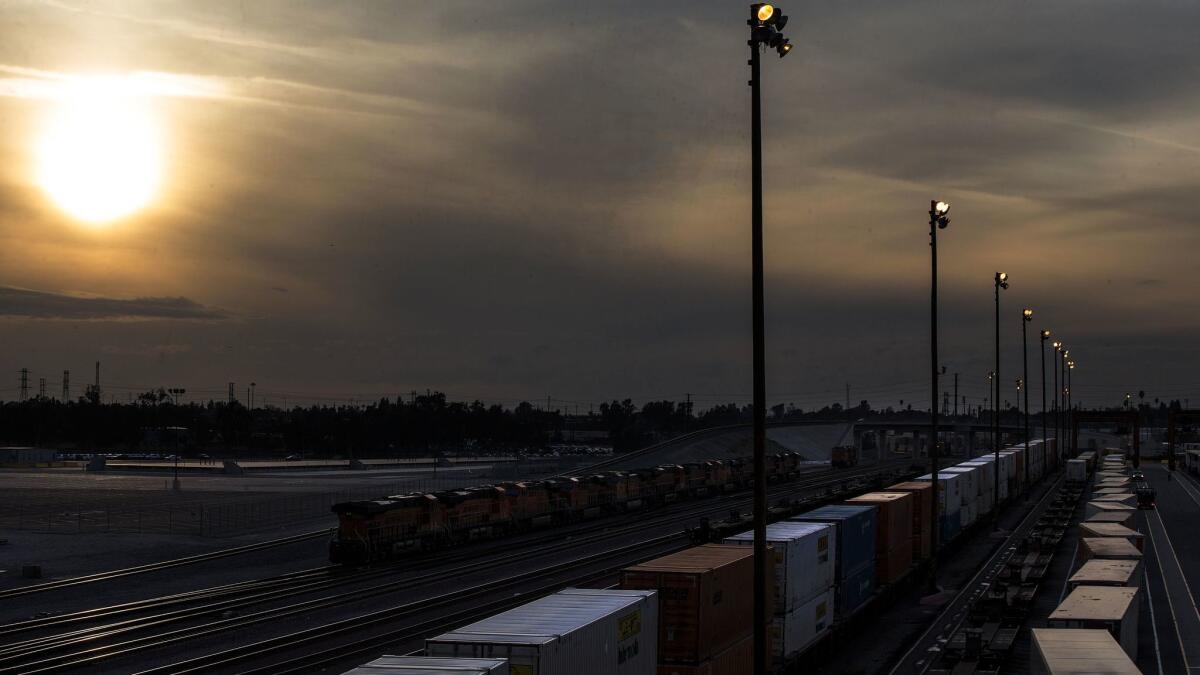 Freight-moving industries have long argued that formal regulations by the region’s air quality district would stifle job growth. Above, a smoggy day over the San Bernardino rail yard.