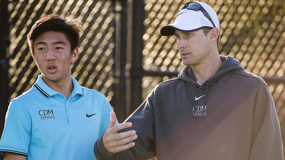 Kyle Pham, left, shown talking to Corona del Mar High boys' tennis coach Jamie Gresh on March 2, 2017, is 17-1 in singles this season for the Sea Kings.