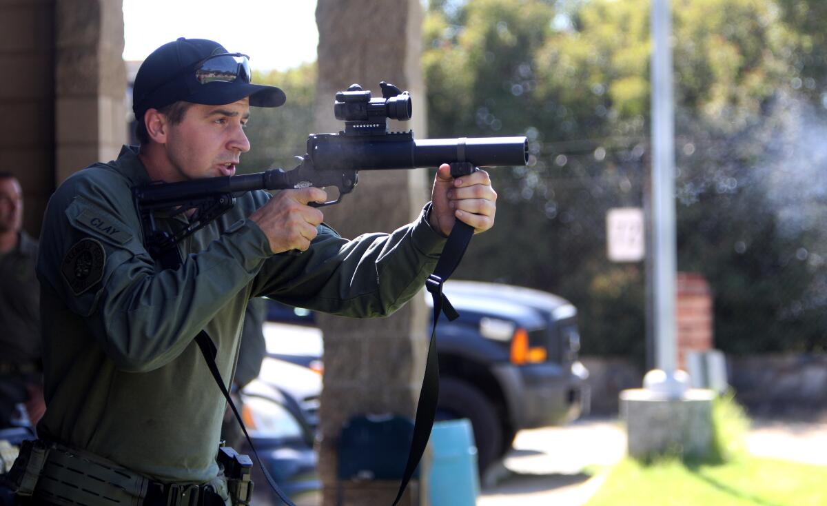 Glendale Police SWAT operations officer Chris Clay demonstrates how a less-than-lethal round is deployed, during a special training day with the Police Advisory Panel at the Glendale Police Department Training Center and Firing Range in Glendale on Saturday, Aug. 24, 2019.