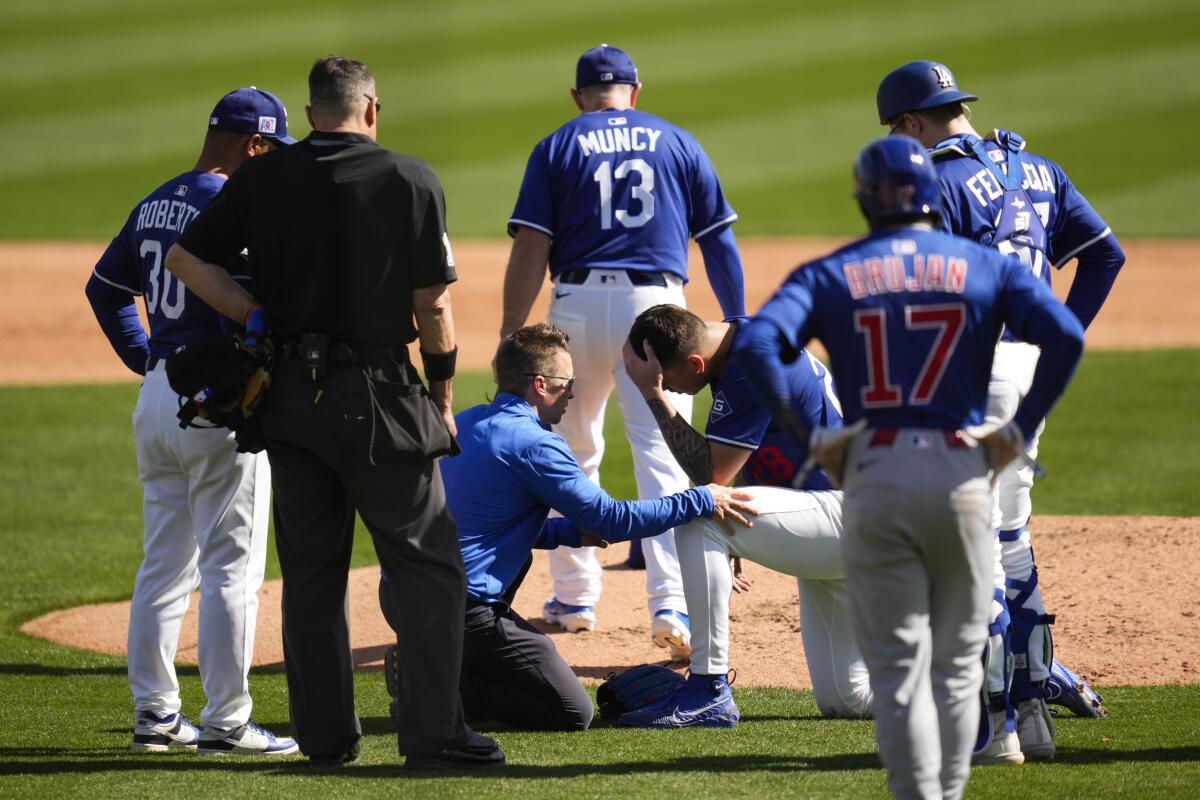 Dodgers sürahi Bobby Miller, bir geri dönüşü kafasından aldıktan sonra bir takım eğitmeni ile konuşur.