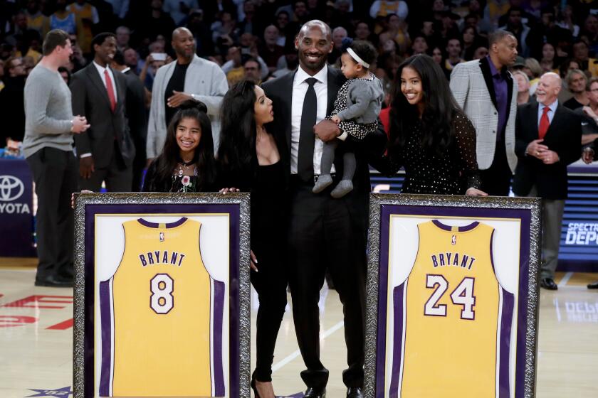 Kobe Bryant poses with his family after getting his jerseys retired before a game between the Lakers and the Golden State Warriors at Staples Center on Dec. 18, 2017.