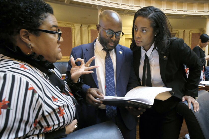 Del. Cia Price, D-Newport News, left, Del. Alex Askew, D-Virginia Beach, center, and Del. Jennifer Carroll Foy, D-Prince William, right, confer during the floor session of the Virginia House of Delegates inside the State Capitol in Richmond, Va., on Feb. 11, 2020. Election officials were painstakingly recounting votes Thursday, Dec. 2, 2021, in one of two unresolved races in Virginia that will settle whether Republicans have reclaimed the majority in the state's House of Delegates and completed a party sweep of last month's contests. Representatives from both the Republican and Democratic parties took part in the secondary counting of ballots requested by Democratic Del. Alex Askew, who currently represents the 85th House District. (Bob Brown/Richmond Times-Dispatch via AP)