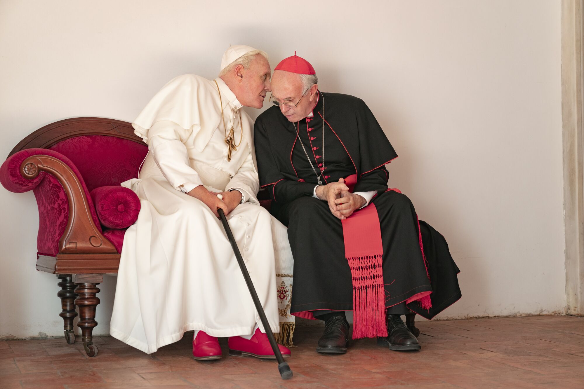 Anthony Hopkins y Jonathan Pryce conversan en la pantalla en "Los dos papas" en una réplica de la Sala de las Lágrimas del Vaticano.