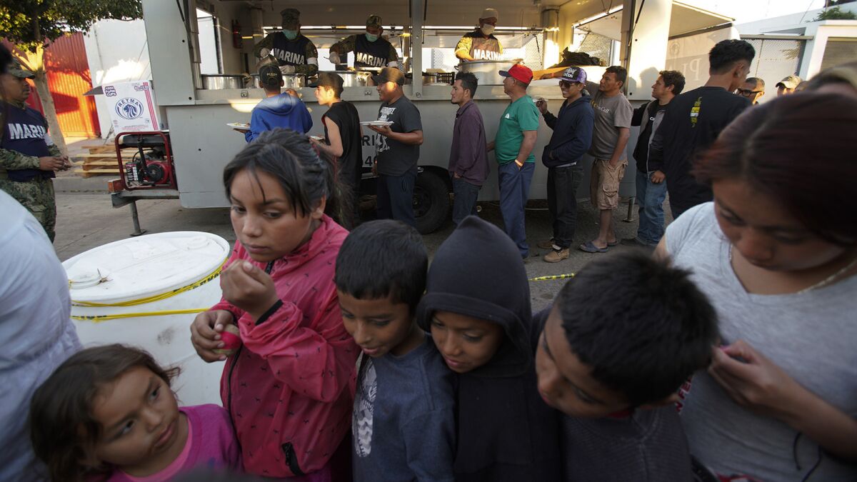 The day after the border clash between migrants and U.S. Border Patrol, life continued as children waited in one line for food and men in another line.