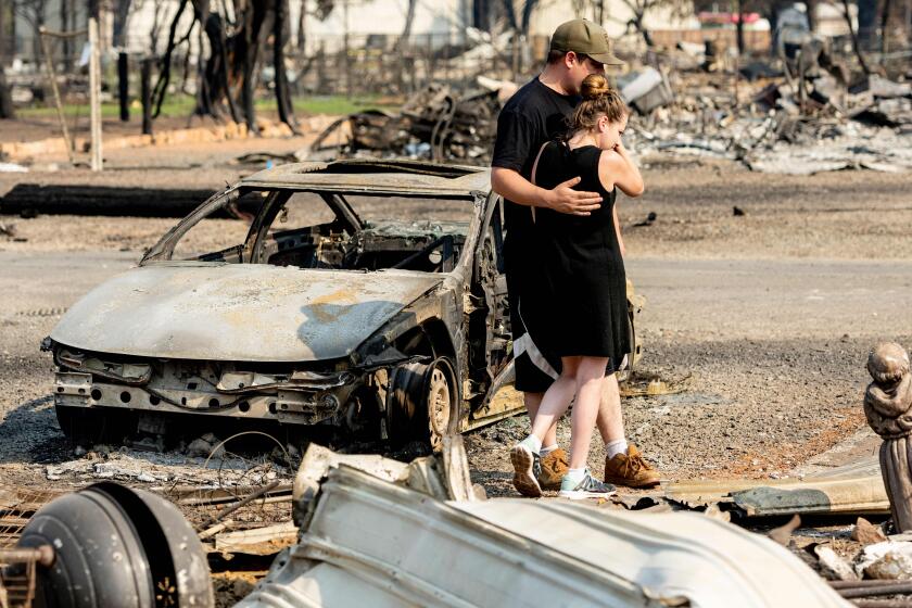Riley Cantrell (R) cries while she and her boyfriend Bradley Fairbanks (L) view what's left of her mother's home that burned down during the Dixie fire in Greenville, California on September 4, 2021. - The Cantrell's family dog died at the home and was buried by firefighters who later found it. (Photo by JOSH EDELSON / AFP) (Photo by JOSH EDELSON/AFP via Getty Images)